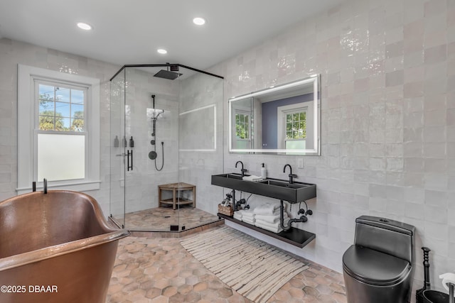 full bathroom featuring toilet, a stall shower, tile walls, and recessed lighting