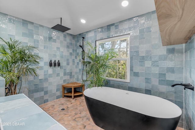 bathroom featuring recessed lighting, walk in shower, tile walls, and tile patterned floors