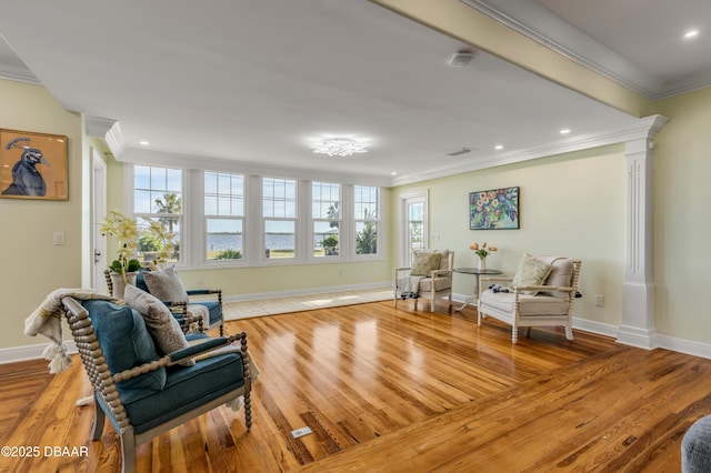 living area with light wood finished floors, baseboards, and crown molding