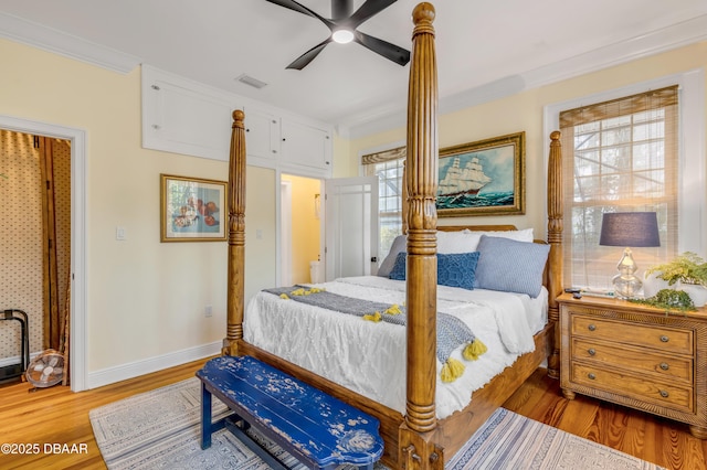 bedroom with baseboards, visible vents, a ceiling fan, wood finished floors, and crown molding