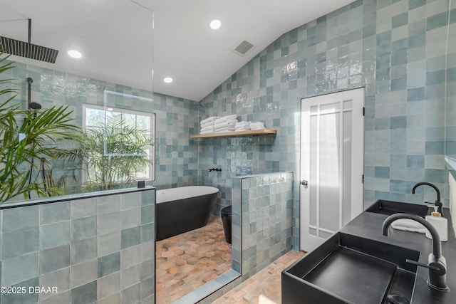 bathroom featuring a sink, walk in shower, and tile walls