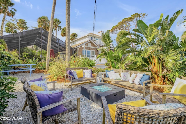 view of patio featuring an outdoor living space with a fire pit and glass enclosure