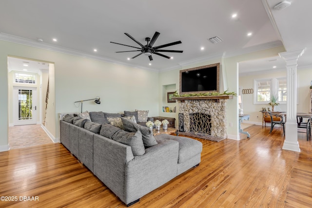 living room with ornamental molding, wood finished floors, visible vents, and ornate columns