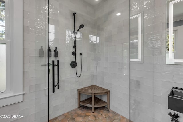 full bath featuring plenty of natural light, tile walls, and walk in shower