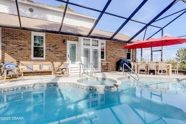 view of swimming pool with glass enclosure, a pool with connected hot tub, outdoor lounge area, and a patio