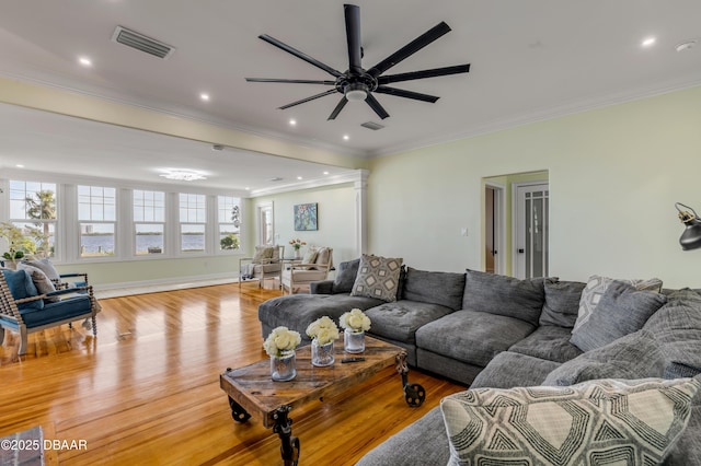 living room with light wood-type flooring, recessed lighting, visible vents, and ornamental molding