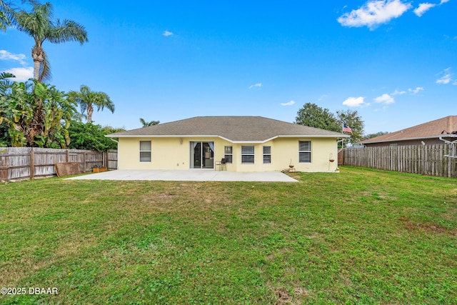 back of house with a yard, a fenced backyard, a patio, and stucco siding