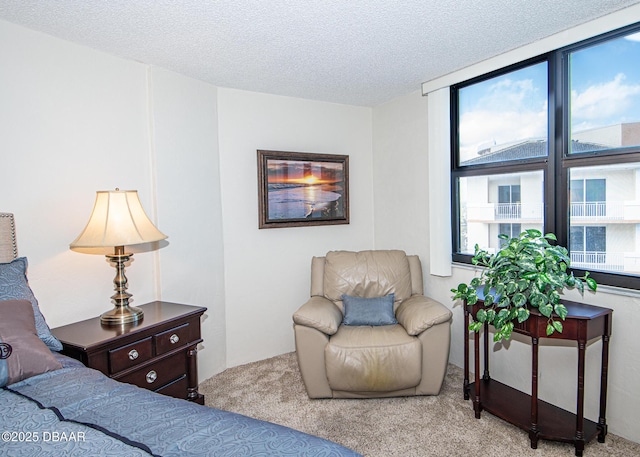 bedroom with light colored carpet and a textured ceiling