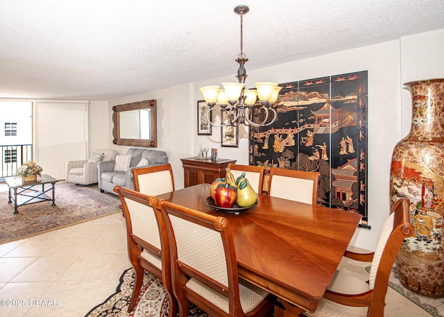 dining area featuring an inviting chandelier, a textured ceiling, and light tile patterned floors