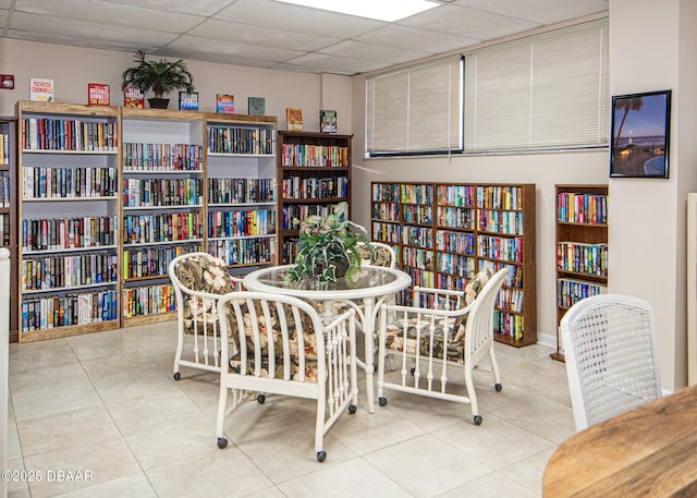 dining room with a paneled ceiling and light tile patterned floors