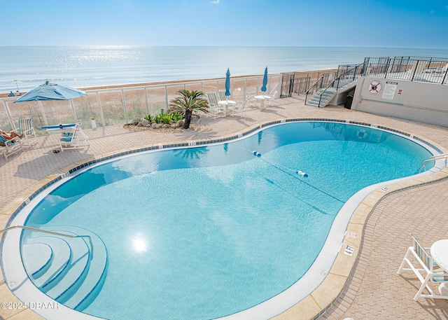 view of swimming pool with a patio and a water view