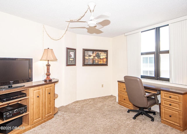 office featuring ceiling fan, light colored carpet, and a textured ceiling