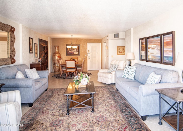 tiled living room featuring a chandelier and a textured ceiling