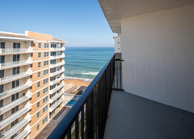 balcony featuring a view of the beach and a water view