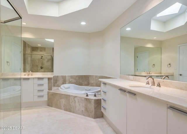 bathroom featuring a skylight, separate shower and tub, and vanity