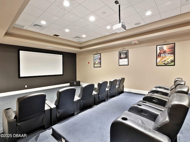 carpeted home theater room with a tray ceiling