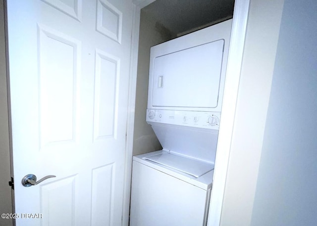 clothes washing area featuring stacked washer / dryer