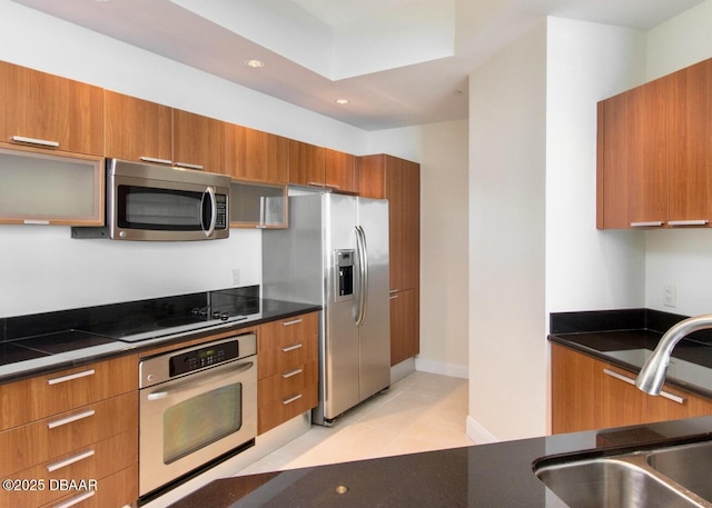 kitchen with appliances with stainless steel finishes, sink, and light tile patterned floors