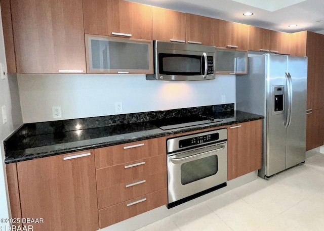 kitchen with dark stone counters and stainless steel appliances