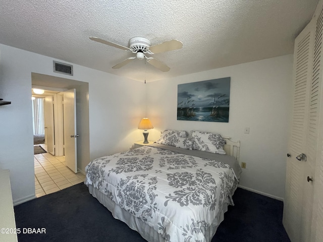 tiled bedroom featuring ceiling fan and a textured ceiling