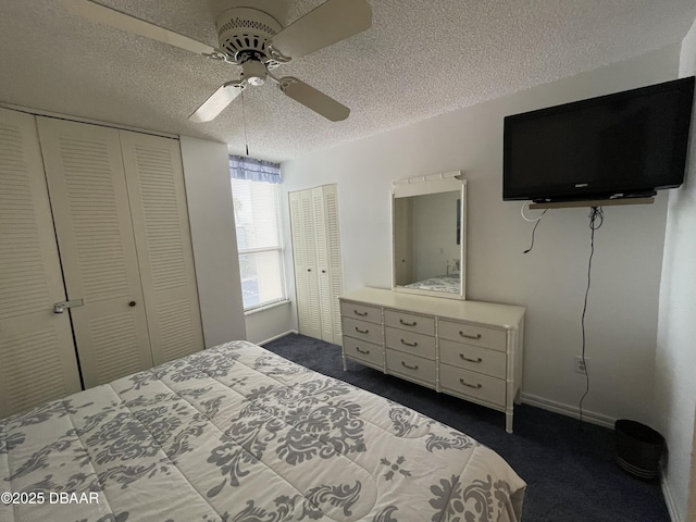 carpeted bedroom featuring multiple closets, ceiling fan, and a textured ceiling