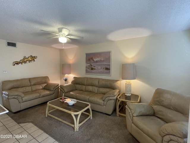 tiled living room with ceiling fan and a textured ceiling