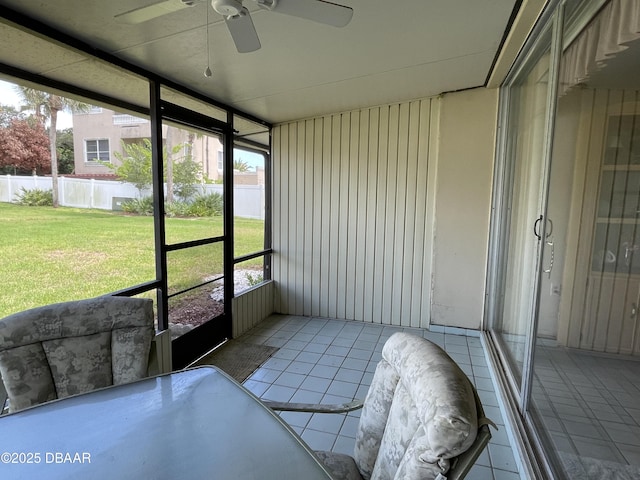 unfurnished sunroom featuring ceiling fan and plenty of natural light