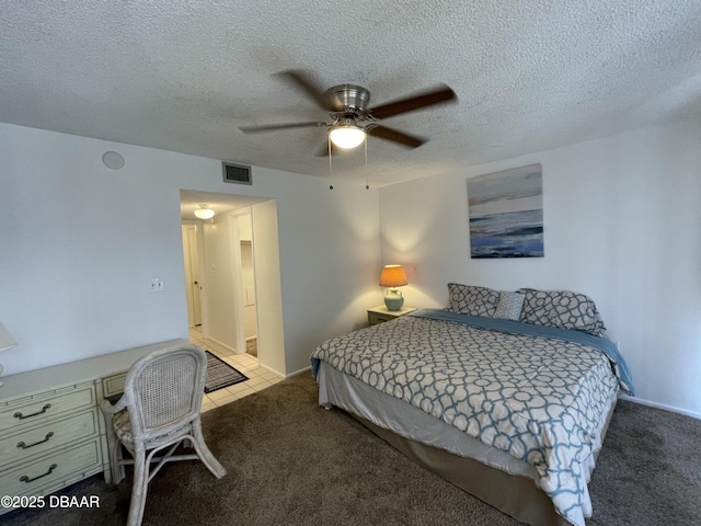 bedroom with ceiling fan, light carpet, and a textured ceiling