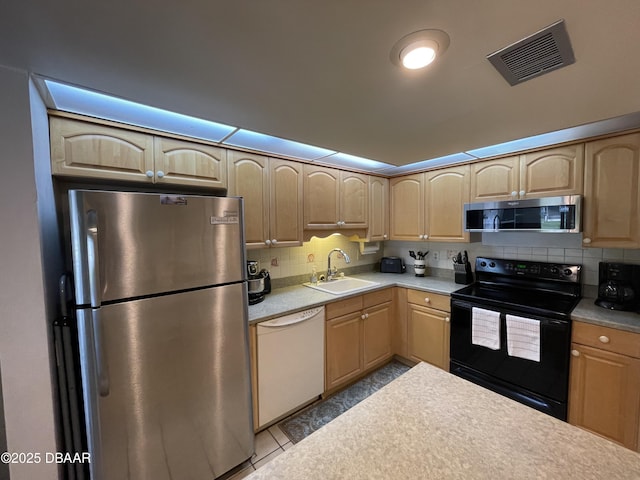 kitchen featuring decorative backsplash, appliances with stainless steel finishes, light brown cabinets, and sink