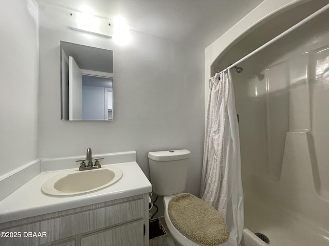 bathroom featuring vanity, curtained shower, and toilet