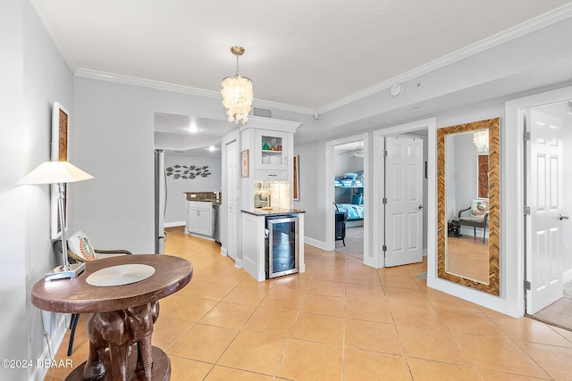 kitchen featuring beverage cooler, crown molding, light tile patterned floors, and white cabinets