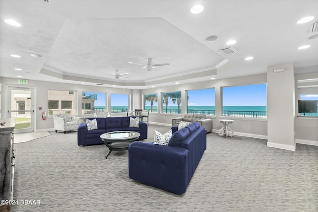 living area with visible vents, a raised ceiling, baseboards, ornamental molding, and carpet