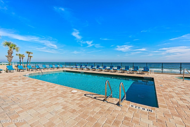 community pool with a patio and fence
