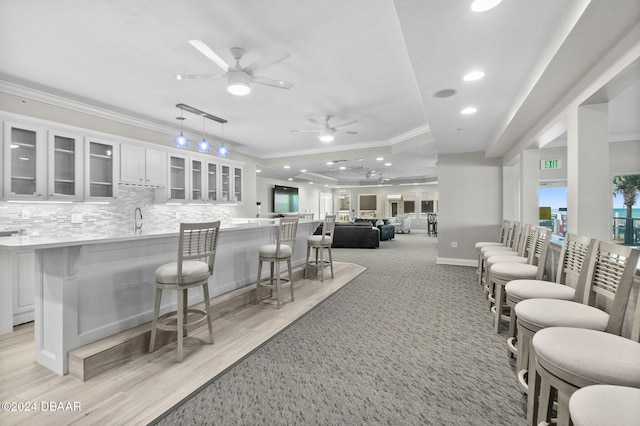 interior space featuring crown molding, decorative backsplash, a sink, recessed lighting, and a ceiling fan