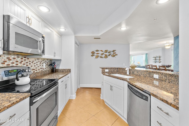kitchen with a sink, white cabinetry, tasteful backsplash, and stainless steel appliances