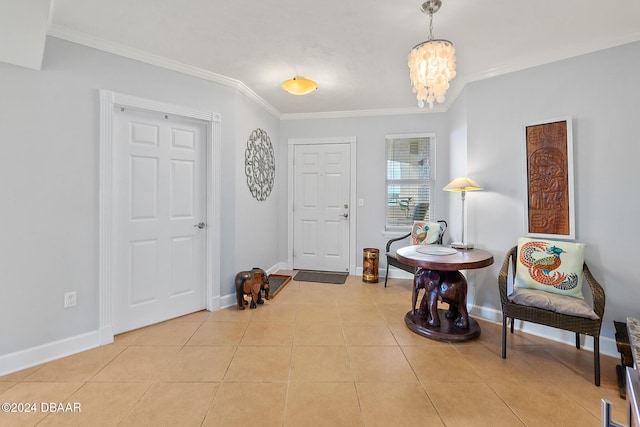 foyer with an inviting chandelier, baseboards, ornamental molding, and light tile patterned flooring