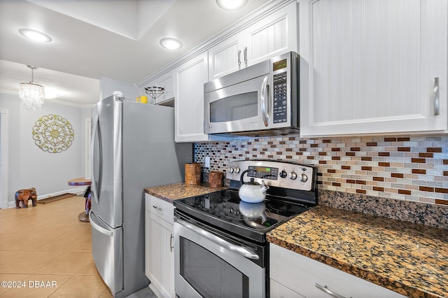 kitchen with backsplash, appliances with stainless steel finishes, light tile patterned floors, baseboards, and white cabinetry