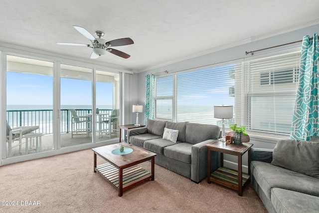 carpeted living room featuring crown molding, a ceiling fan, and a water view
