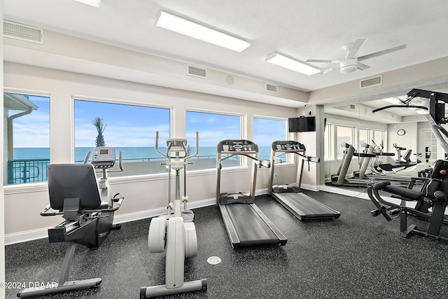 gym with visible vents, a ceiling fan, baseboards, and a healthy amount of sunlight