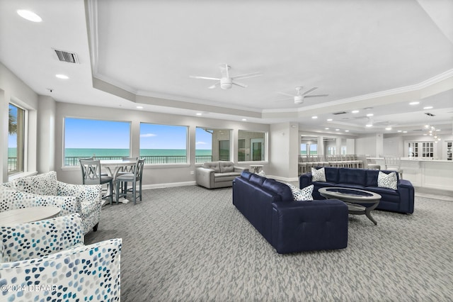 living area featuring ornamental molding, carpet, and a tray ceiling