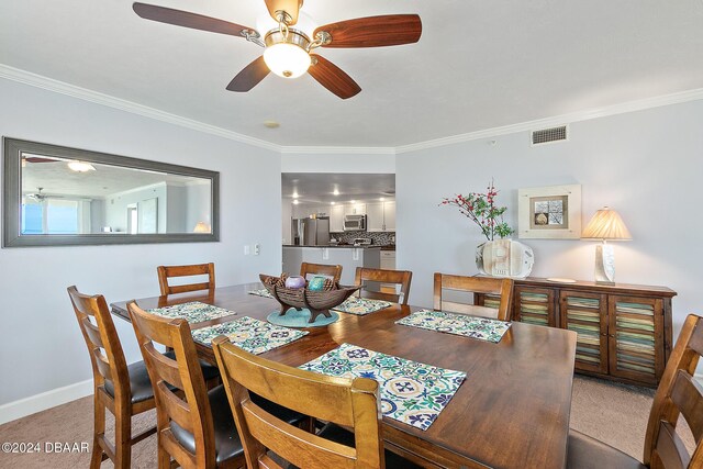 3311 S Atlantic Ave Unit 304, Daytona Beach Shores, FL 32118 - dining area with visible vents, ornamental molding, baseboards, light colored carpet, and a ceiling fan