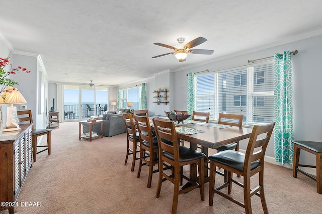 dining room with ceiling fan, light colored carpet, and ornamental molding