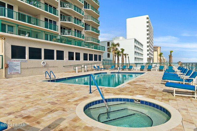 3311 S Atlantic Ave Unit 304, Daytona Beach Shores, FL 32118 - community pool featuring a patio, a hot tub, and fence