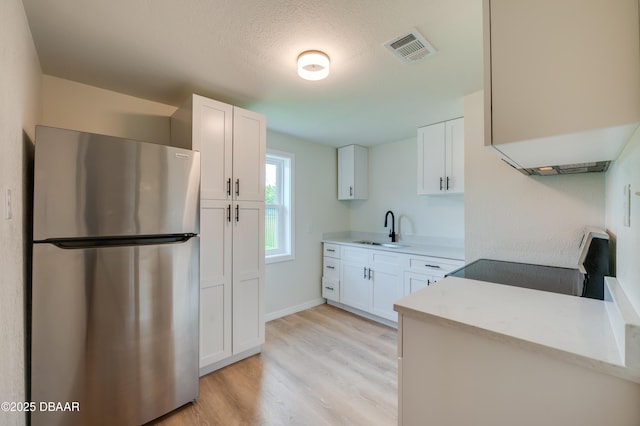 259 Jefferson St, Daytona Beach, FL 32114 - kitchen featuring freestanding refrigerator, range, light wood finished floors, and white cabinets