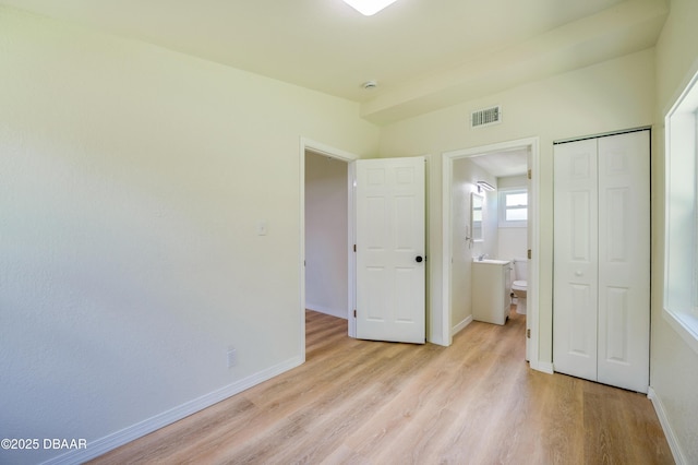 259 Jefferson St, Daytona Beach, FL 32114 - unfurnished bedroom with light wood-type flooring, a closet, and ensuite bath