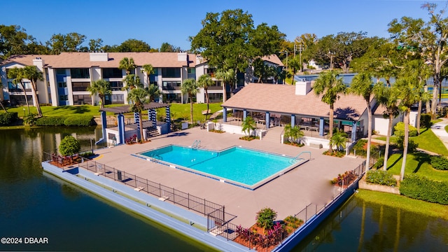 view of pool featuring a water view and a patio area