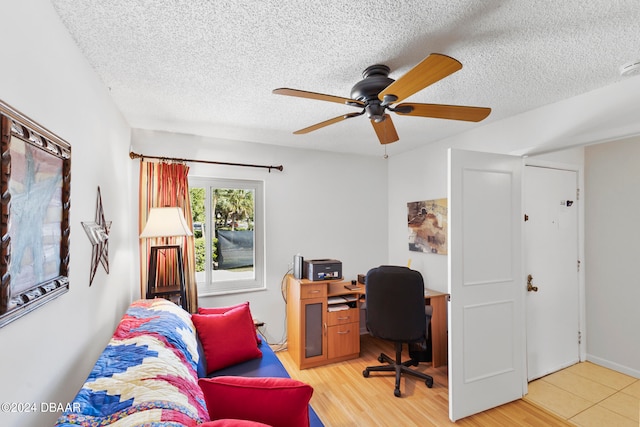 home office with wood-type flooring, ceiling fan, and a textured ceiling