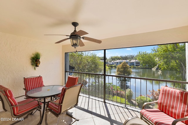 sunroom / solarium featuring ceiling fan and a water view