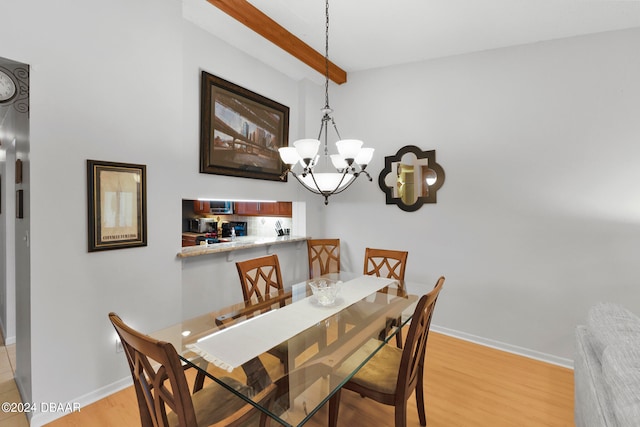 dining area featuring beamed ceiling, a chandelier, and light hardwood / wood-style flooring