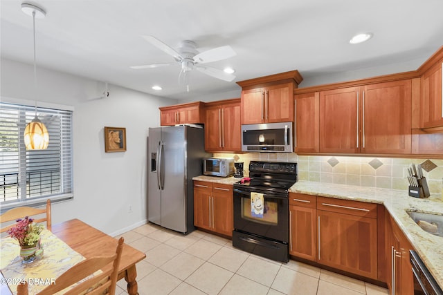 kitchen featuring light stone counters, ceiling fan, backsplash, pendant lighting, and appliances with stainless steel finishes